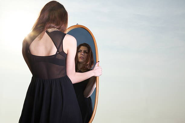 istock thoughtful woman looks at the reflection in mirror 178150478