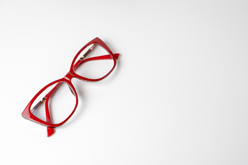 Modern women's glasses in red frames on a white background with copy space for advertising and text