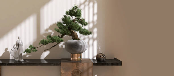 istock Large bonsai tree and oriental decorative items on black marble console table in sunlight, shoji window grill shadow on beige brown wall 1781514584