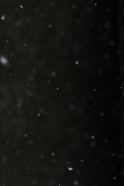 istock Bokeh of white snow on a black background. Snowfall - design element. 1781514603
