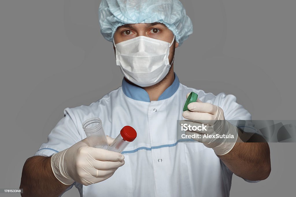 Giovane medico con contenitore per l'analisi - Foto stock royalty-free di Adulto