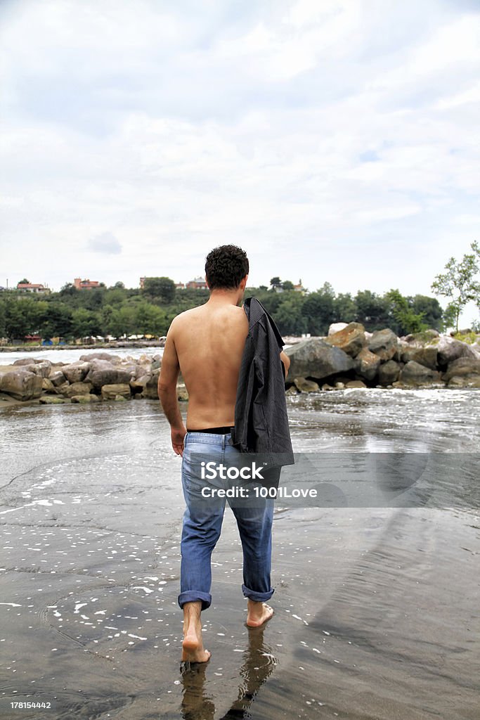 Joven atractivo y media naked Hombre caminando en la playa - Foto de stock de Adulto libre de derechos