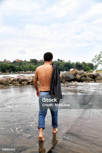 Joven Atractivo Y Media Naked Hombre Caminando En La Playa Foto de stock y más banco de imágenes de Adulto