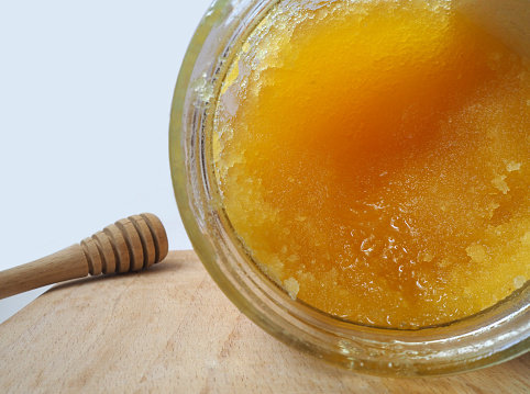 Isolated crystallized honey in a glass jar. Selected focus. Selected focus.