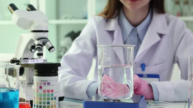 Laboratory scientist scientist throws potassium permanganate dissolved in water