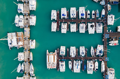 Aerial view of yachts and boat berthed in the marina and clear water