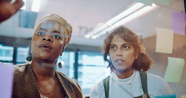 istock Sticky notes, business people and women brainstorming, cooperation and teamwork with planning, thinking and writing on a board. Staff, creative agency or manager with employee, idea and collaboration 1781573807