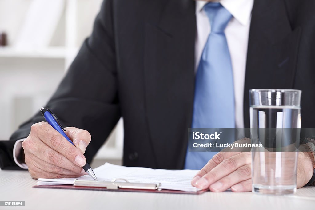 Empresário escreve com caneta sobre documentos - Foto de stock de Adulto royalty-free
