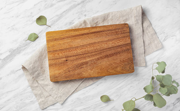 istock Wood board on linen napkin on marble kitchen table wtih green leaves 1781590810