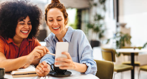 istock Two business women using a smartphone together during a coffee break 1781591223