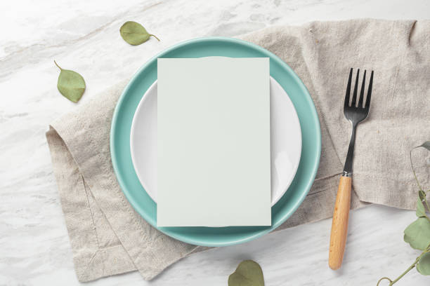 istock Green blank menu card mockup on plate with fork on linen napkin on marble table 1781592248