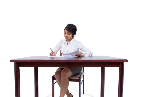 Attractive businesswoman writing notes at her desk