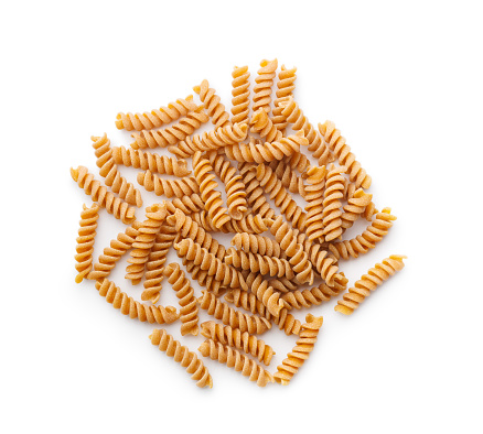 Raw whole grain fusilli pasta. Uncooked pasta isolated on the white background.