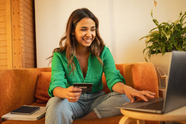 istock Latin woman using her credit card to pay online 1781607983