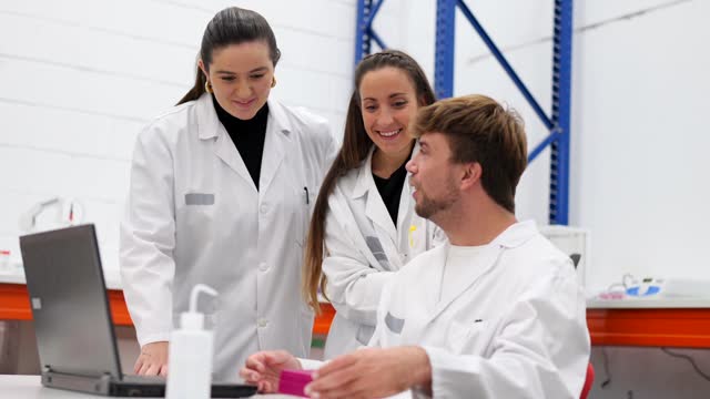 Three scientists talking in a laboratory