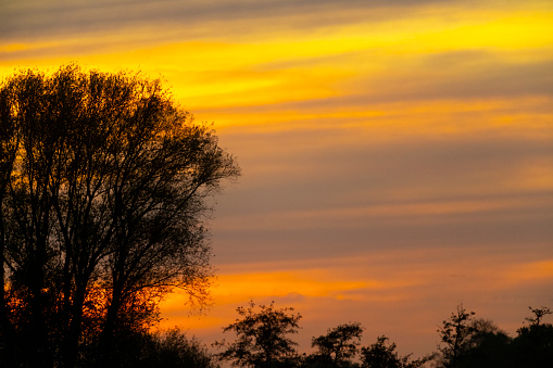 Digital composite sunset view over fields to a lake in the distance in the Lake District of Cumbria, England.