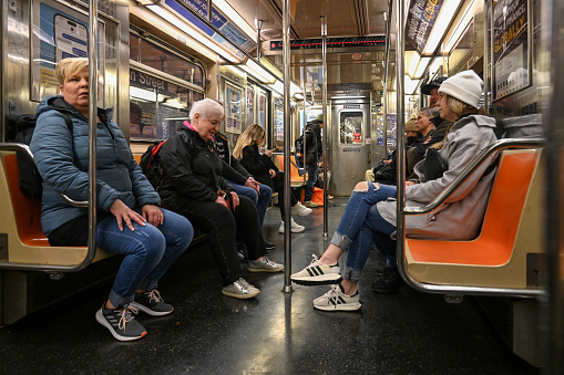 New York, New York, USA, April 7, 2023 - Tourists and locals traveling on a subway train in New York City.