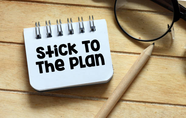 istock Stick To The Plan words in a small notebook on a wooden table. 1781645430