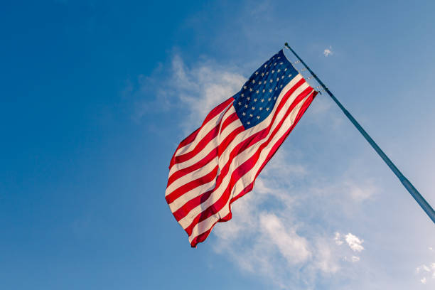 American USA flag on a flagpole waving in the wind
