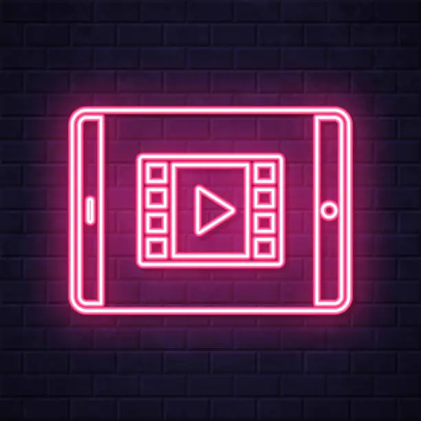 Vector illustration of Watch video on tablet PC. Glowing neon icon on brick wall background