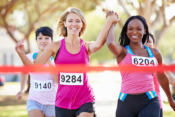 deux femmes coureurs terminer la course ensemble - muscular build action human muscle black and white photos et images de collection