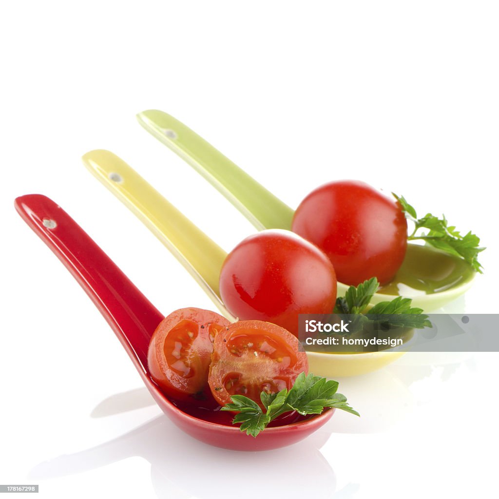 Cherry tomatoes Fresh tomatoes and parsley leaves  on ceramic spoons. Appetizer Stock Photo