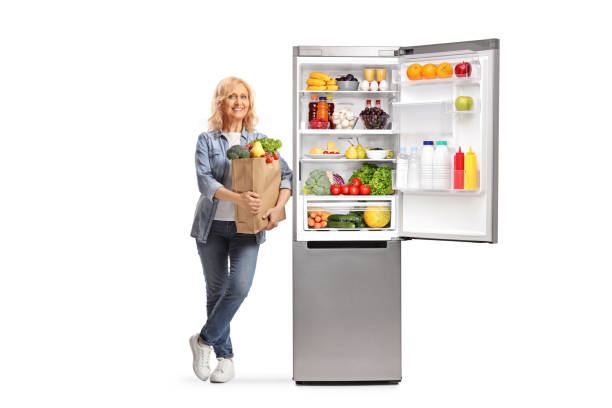 istock Mature woman with a grocery bag leaning on an open fridge 1781685447