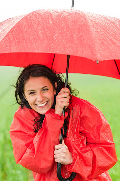 istock Wet young girl enjoying rainfall with umbrella 178168797