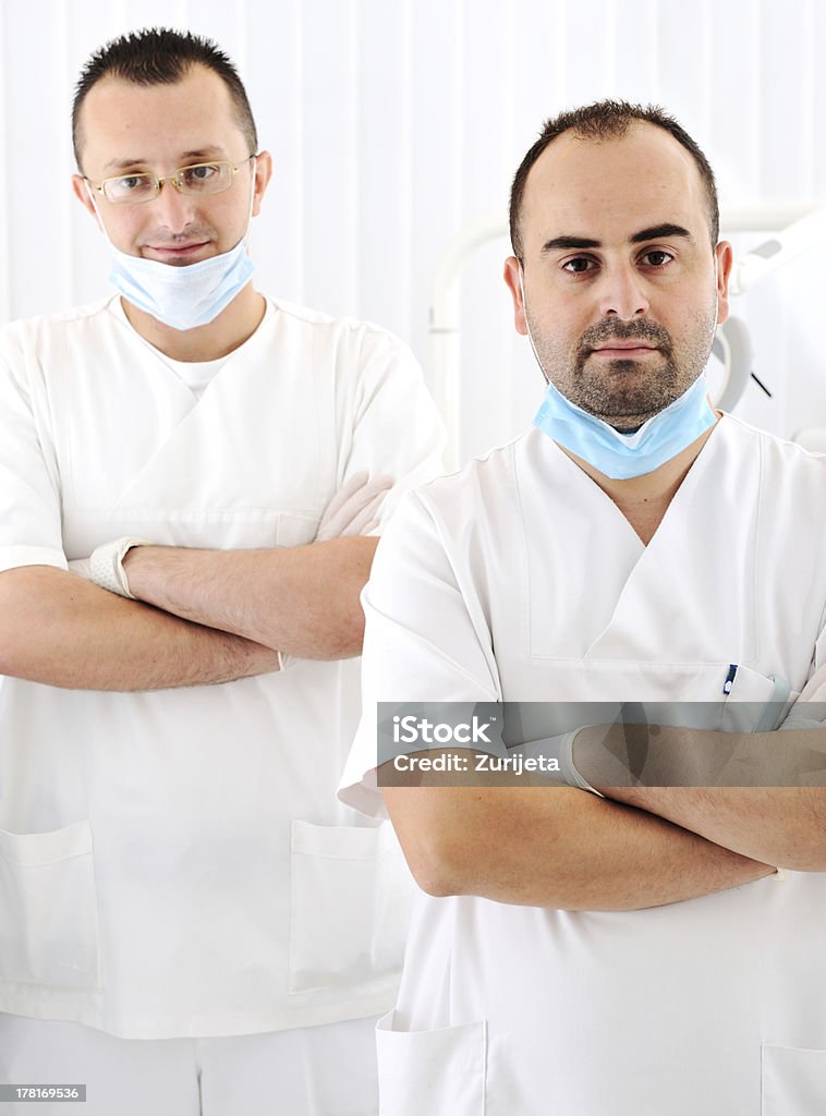 Retrato de dois sorrindo Doutor em pé com as mãos dobradas - Foto de stock de Adulto royalty-free