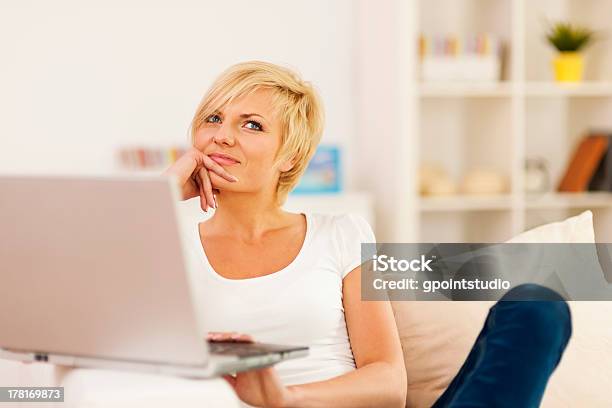 Foto de Retrato De Mulher Com Laptop Pensativo e mais fotos de stock de Aconchegante - Aconchegante, Adulto, Beleza