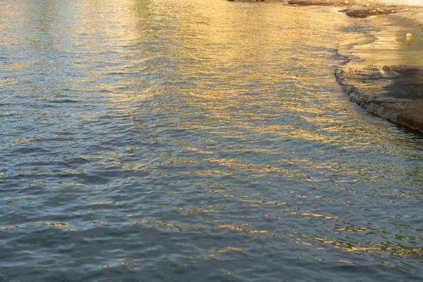 abstract reflections of sunlight on the rippled water surface on the Mediterranean coast