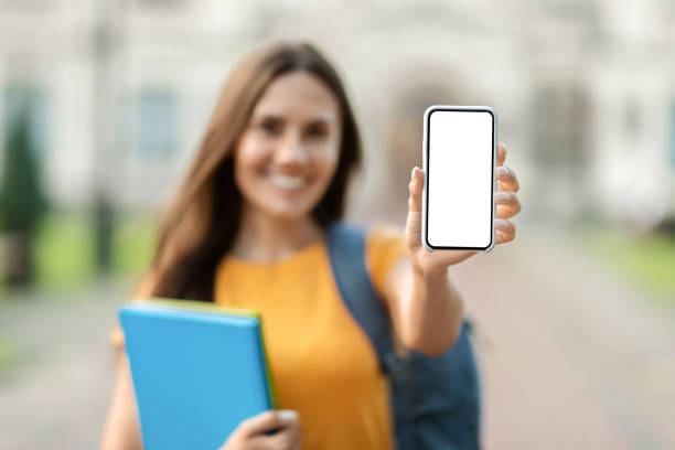 istock Great App. Happy Beautiful Student Female Showing Smartphone With Empty Screen 1781711743