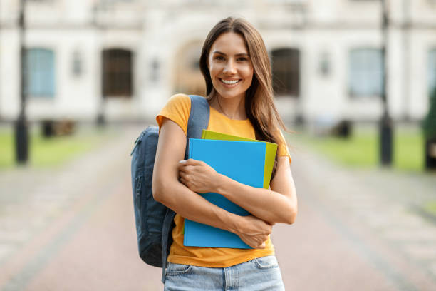 istock Beautiful Female Student With Backpack And Workbooks Posing Outdoors Near College Building 1781712841