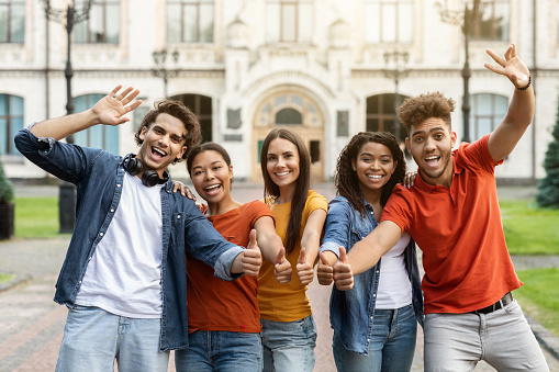 We Recommend. Group Of Cheerful Multiethnic Students Gesturing Thumbs Up At Camera While Posing Outdoors, Happy Young College Friends Recommending Educational Or Tuition Program, Enjoying Study