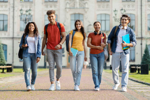 istock Happy university students walking together on campus, laughing and looking at camera 1781713126