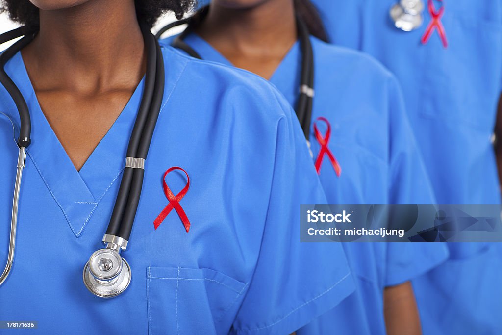 african medical doctors with red ribbon group of african medical doctors with red ribbon for AIDS awareness AIDS Stock Photo