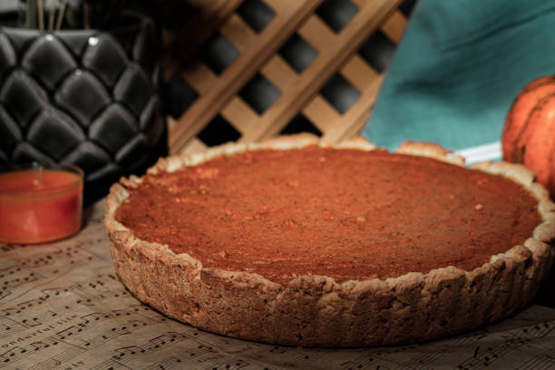 istock pumpkin pie round shape, dark background, musical notes sheet baking paper, decorative small orange pumpkin vegetable, kitchen textile, rustic style 1781725619