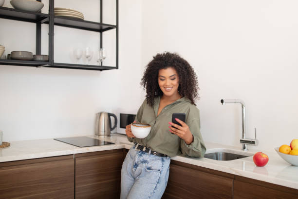 istock Black Woman Using App On Smartphone At Modern Kitchen Interior 1781726210
