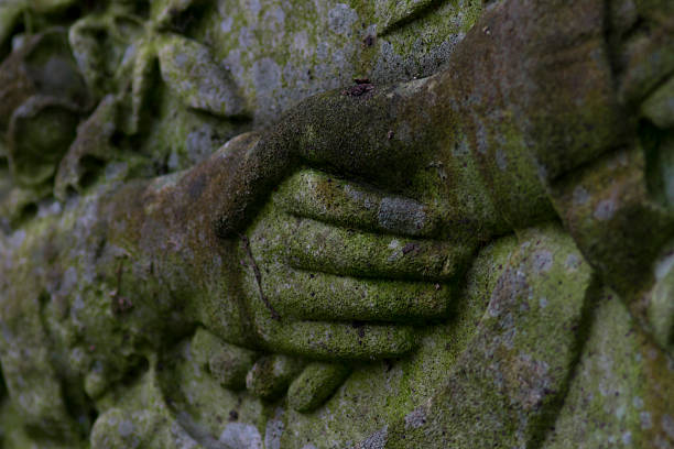 Hand of God and Man on a Headstone stock photo