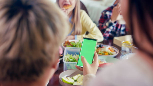 istock Friends Using a Smartphone with a Green Screen During a Party 1781741617