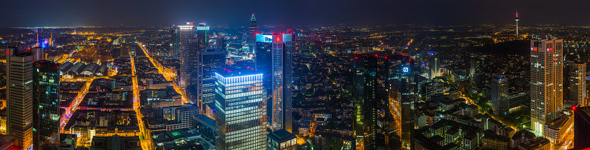 Aerial panoramic view over the central business district skyscrapers and warm lights of the streets of Frankfurt am Main, Germany’s vibrant financial centre.