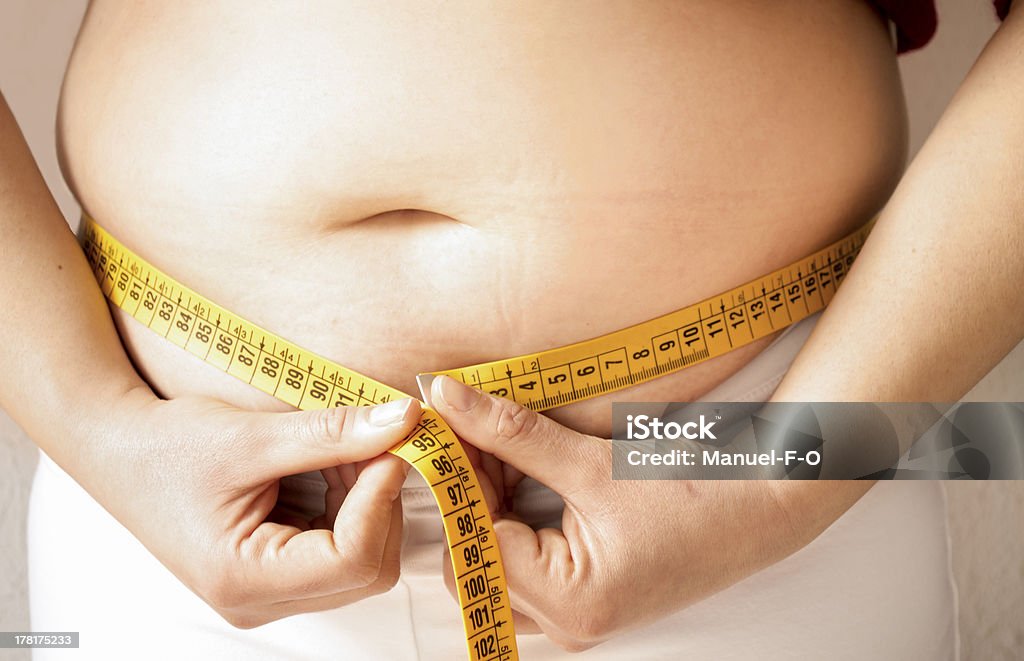 checking fats with a measure tape women female checking fats on her body with a meter Overweight Stock Photo