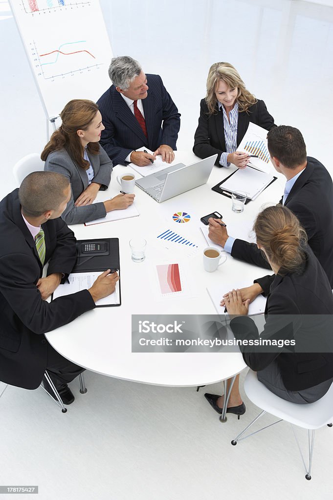 Mixed group in business meeting Mixed group in business meeting sitting around table having a discussion Business Stock Photo