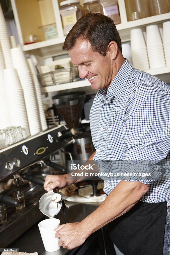 Man working in coffee shop Man working in coffee shop pouring milk smiling 40-49 Years Stock Photo