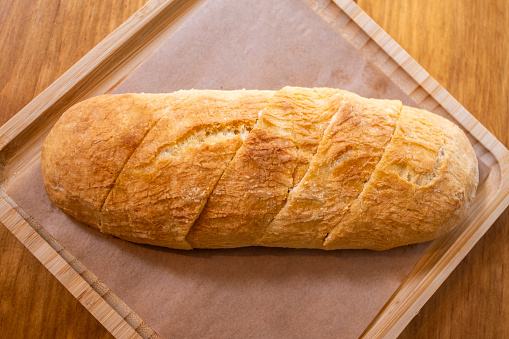 Small white bread on old green wooden table, top view