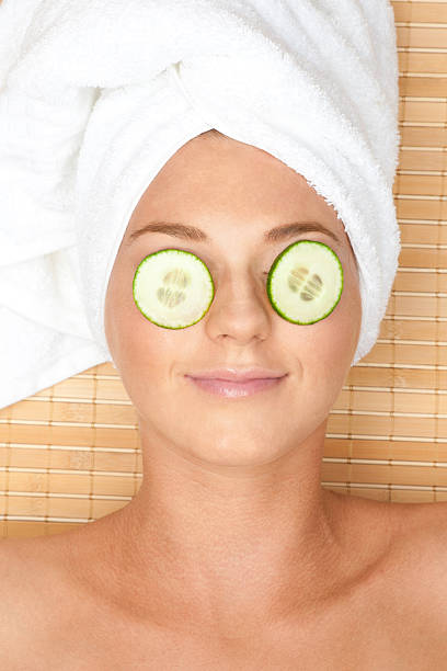 kobieta z twarzy maska z ogórka - cucumber human eye spa treatment health spa zdjęcia i obrazy z banku zdjęć