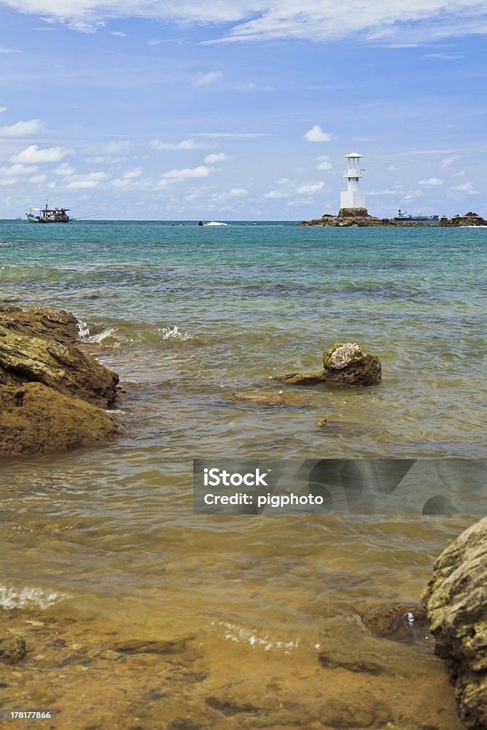 Farol entre mar azul, bluesky e submerso rocks - Foto de stock de Azul royalty-free