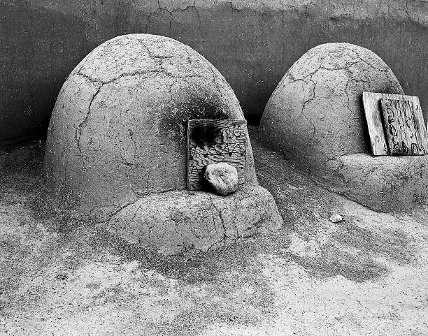 Village Oven Ovens Two hornos ovens in New Mexico Pueblo. Hornos ovens are traditional dome-shaped outdoor ovens used by native Americans in the American Southwest region. (Scanned from black and white film.) adobe oven stock pictures, royalty-free photos & images