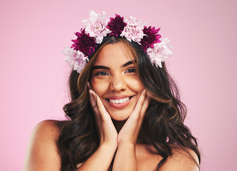 Beauty, flowers and hair with portrait of woman in studio for cosmetics, skincare and wellness. Self care, spa treatment and crown with person on pink background for spring, glow and makeup