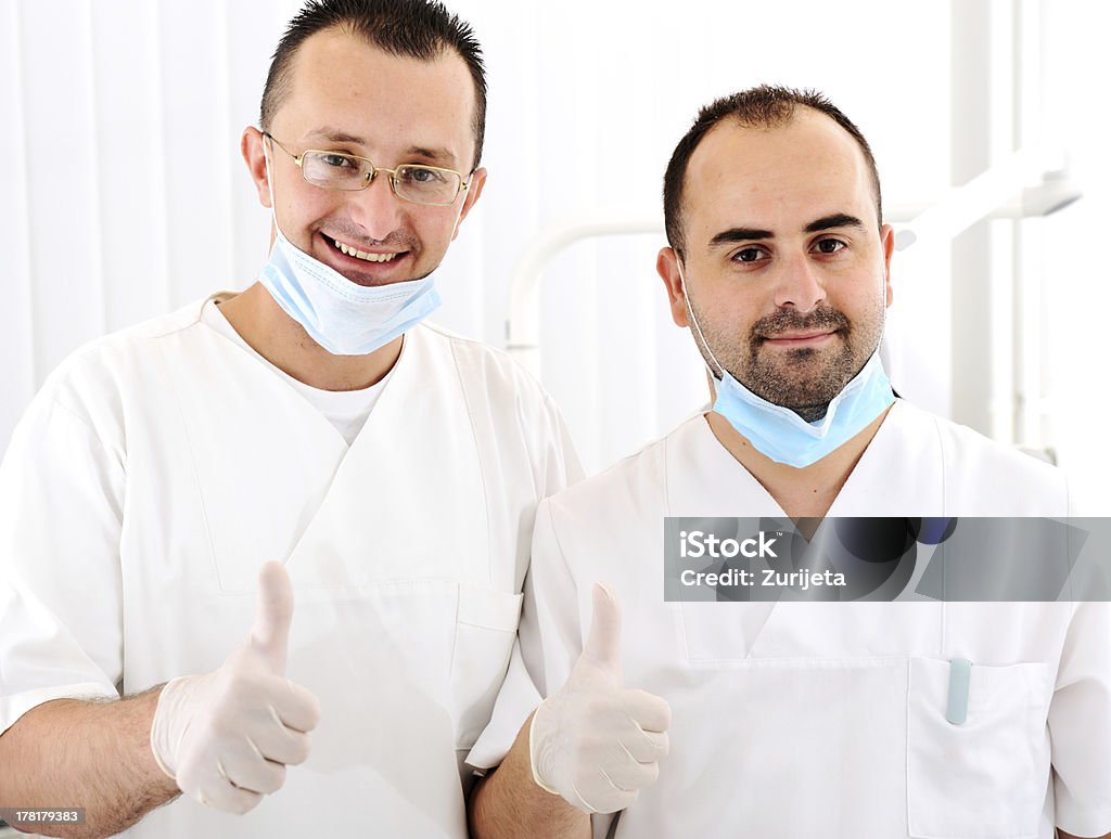 Retrato de dos sonriendo médico de pie con las manos doblado - Foto de stock de Adulto libre de derechos